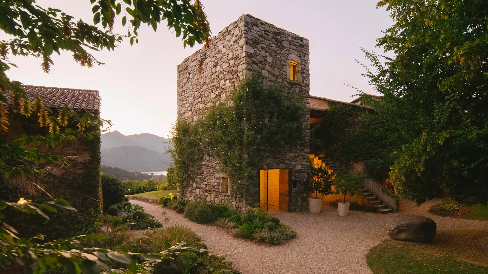 La Darbia — la torre del roccolo tra i giardini, con il lago e le montagne sullo sfondo